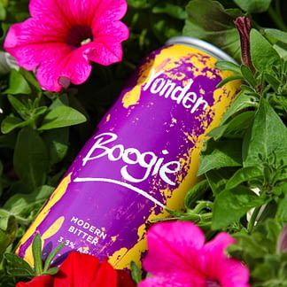 Purple beer can nestled in greenery with pink flowers